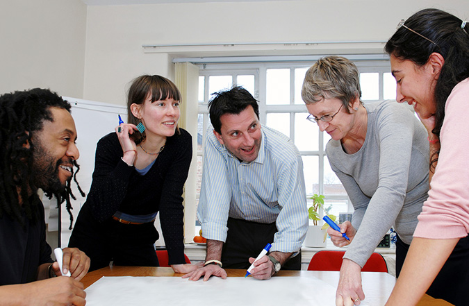 5 professionals collaborate and plan during a working meeting.