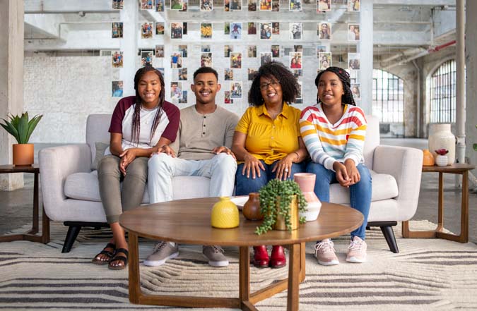 AdoptUSKids spokespeople--mother and three children--sitting on a couch