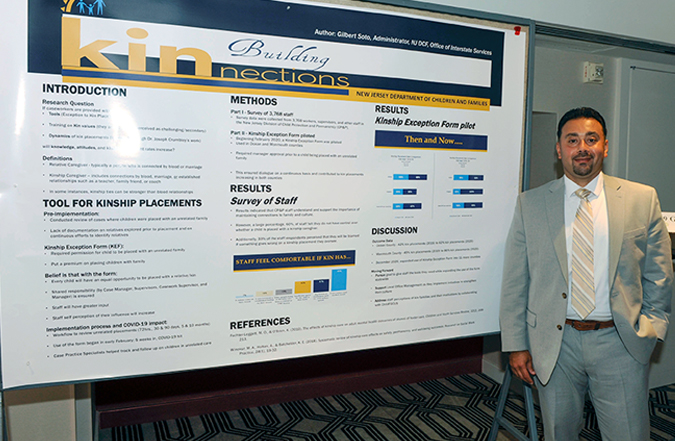 Gilbert Soto stands in front of poster.