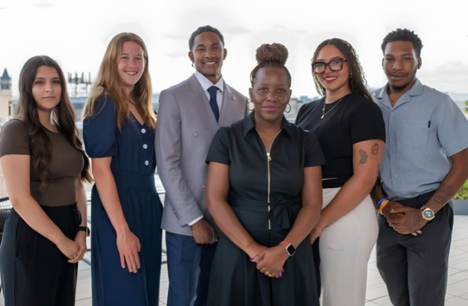 A group of six people pose for a photo together.